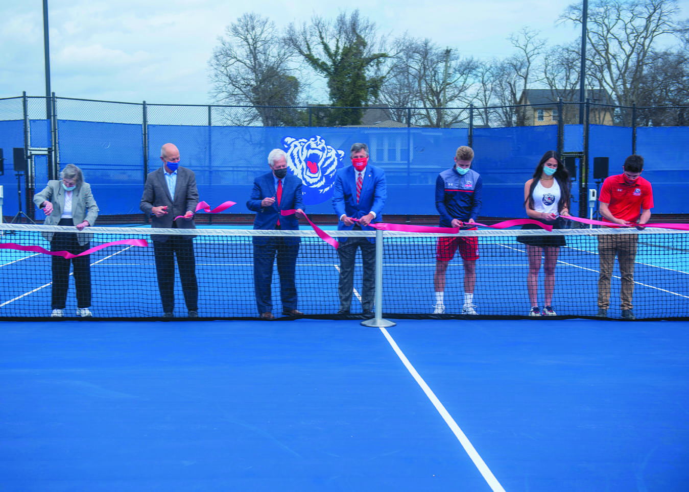 Pat Johnson, Bill DeLoache, Dr. Fisher, Scott Corley, Marko Illic, Somer Henry and Mauricio Antun cut the ribbon during the ceremony opening Belmont's new rooftop tennis facility at Belmont University in Nashville, Tennessee, March 10, 2021. 
